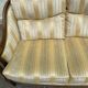 Two-seater Louis XVI canapé in golden beige fabric and curved solid wood.