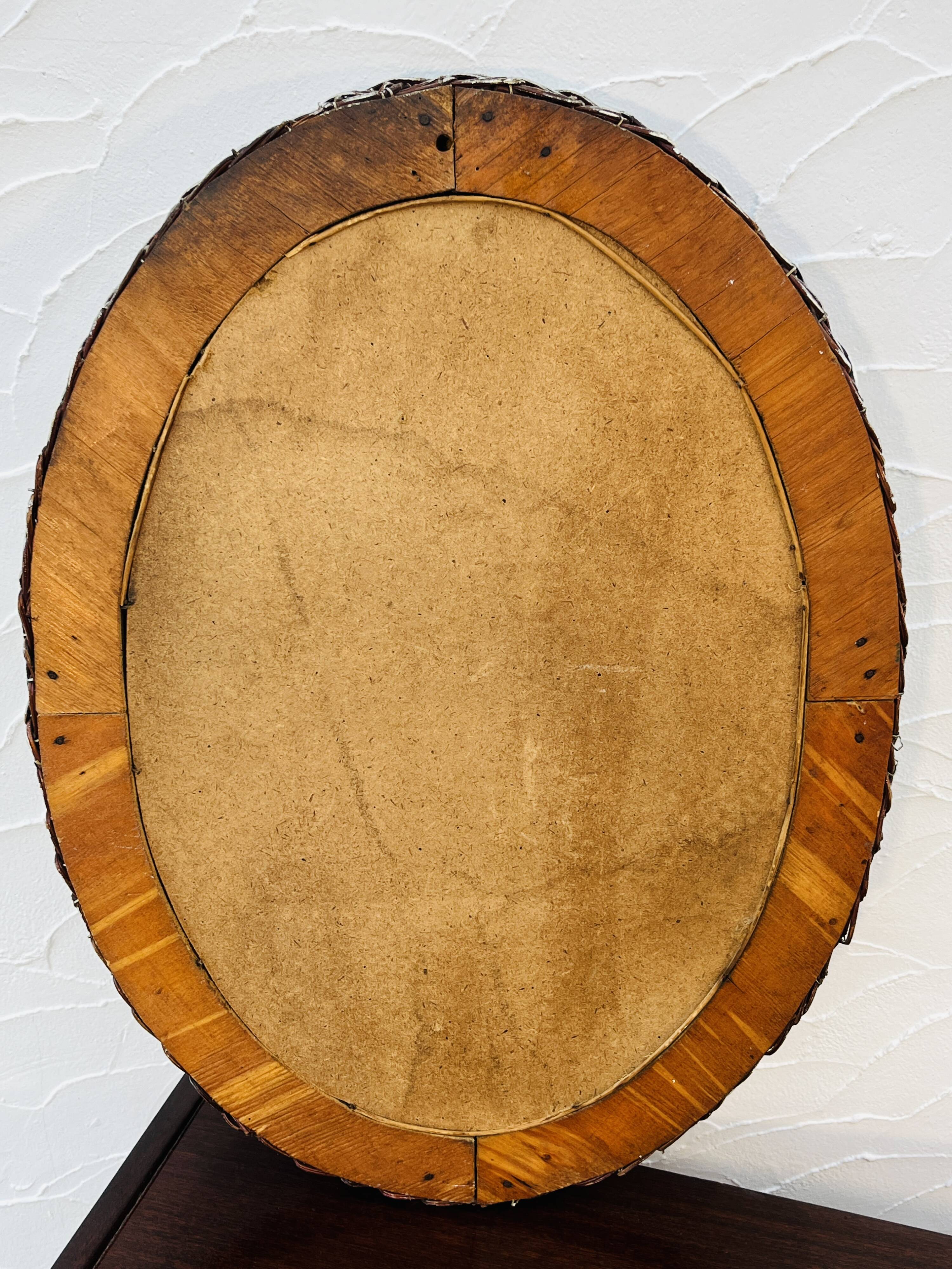 Vintage oval wicker mirror from the 1960s.