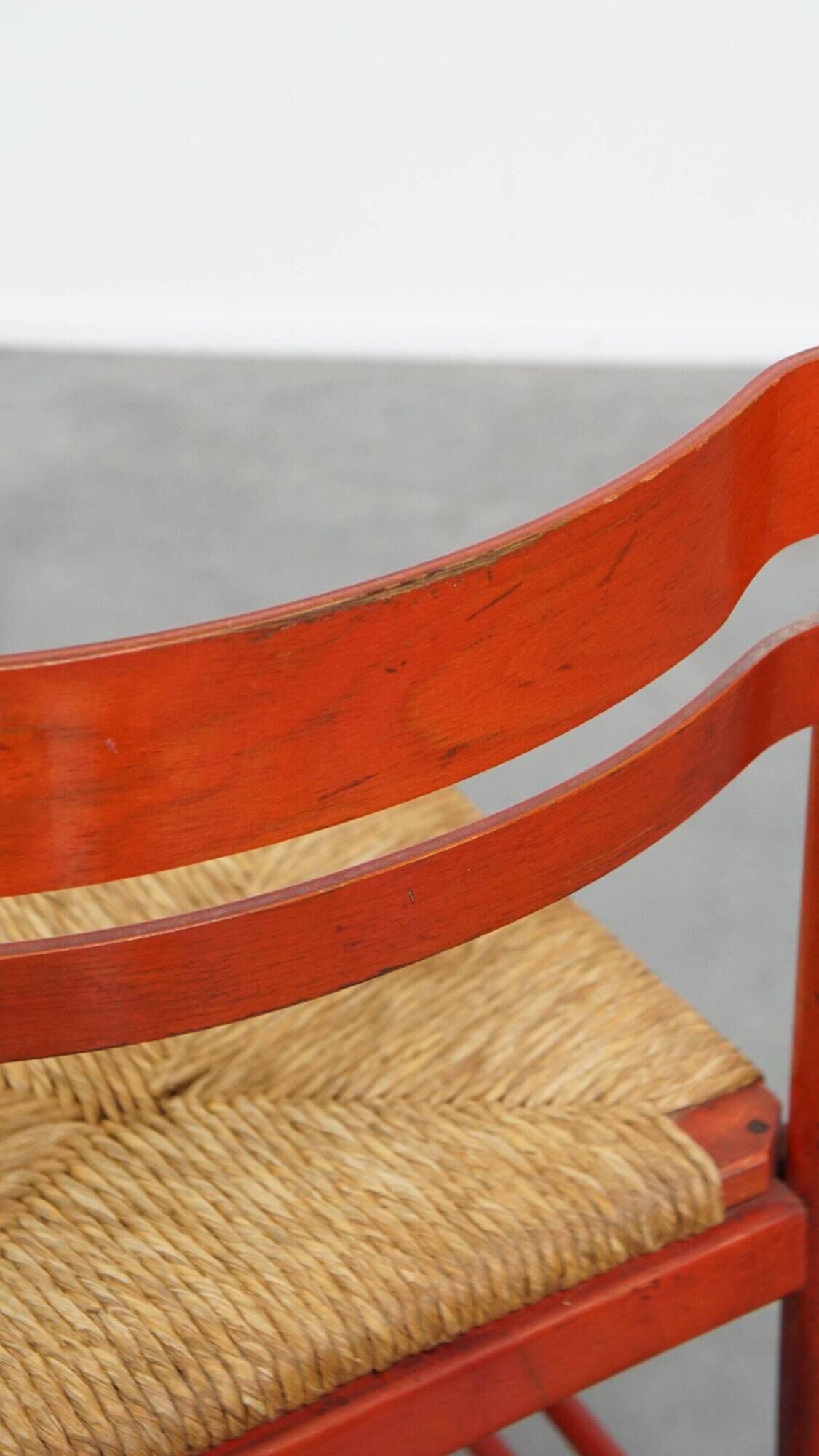 Vintage 1970s red wooden chair with a woven wicker seat