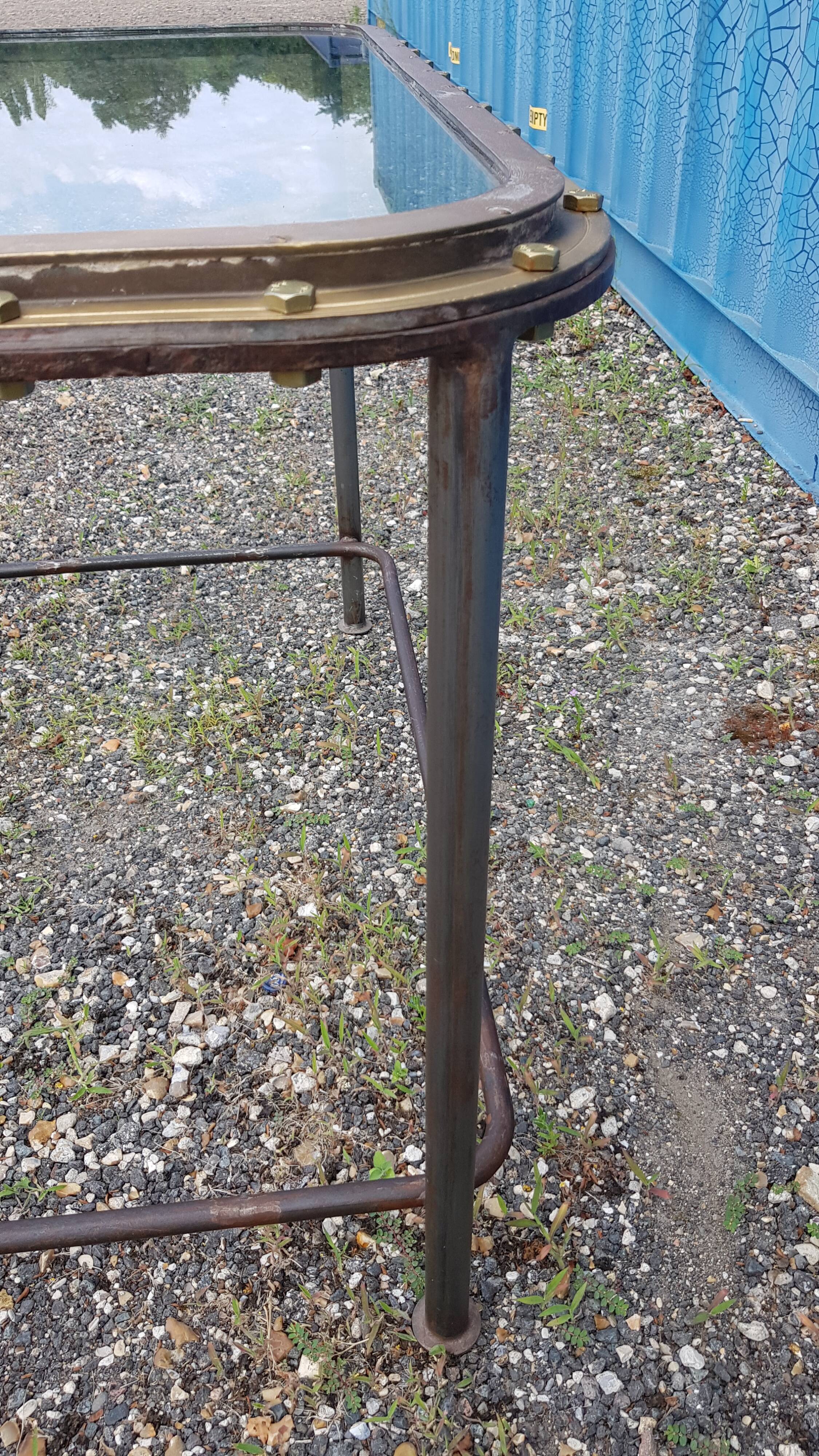 Table with an old ship porthole in brass and a metal base / 110 x 70 x 76 cm