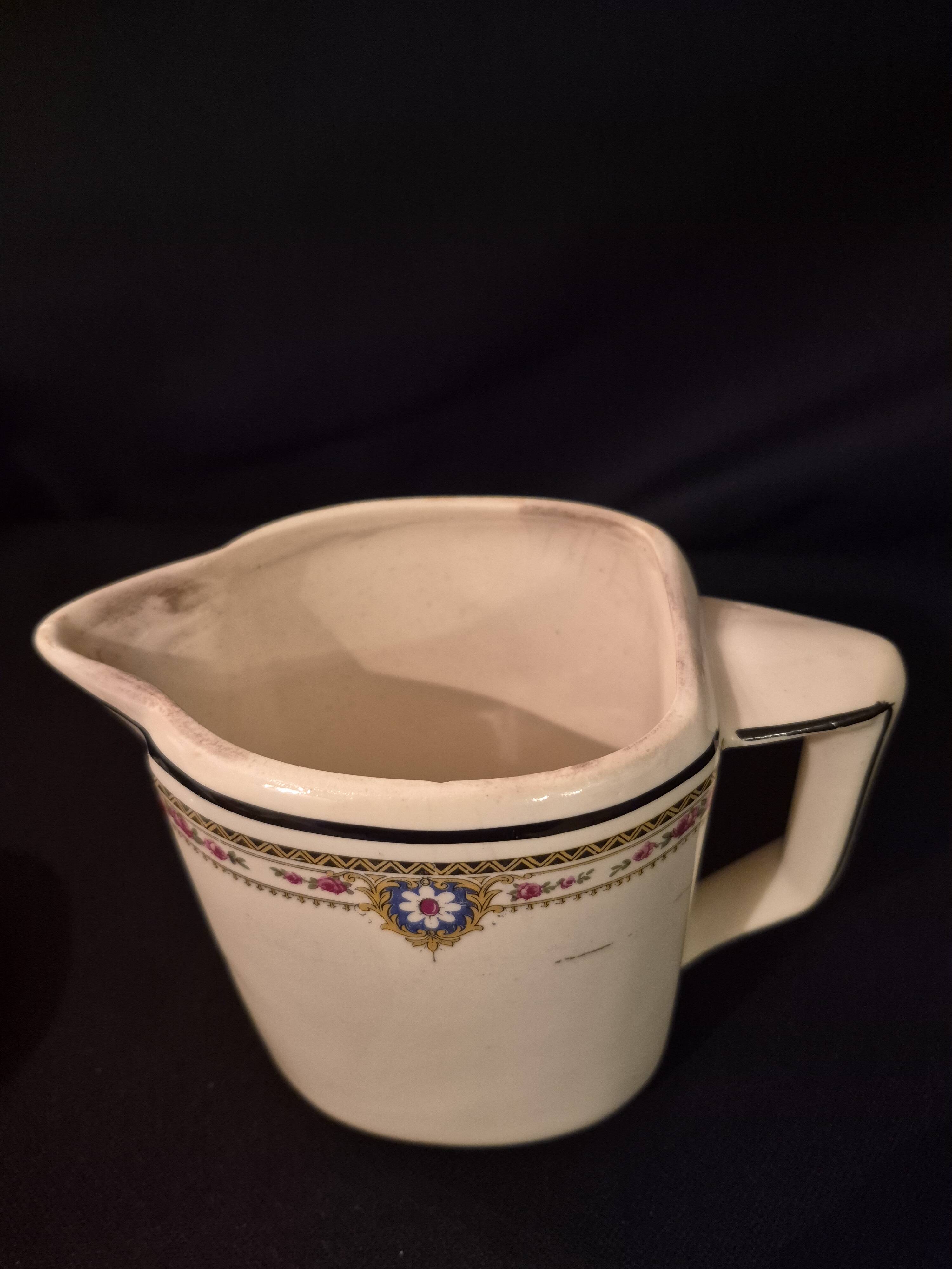 Old covered jug, vintage, geometric frieze with flowers and black trim.