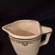 Old covered jug, vintage, geometric frieze with flowers and black trim.