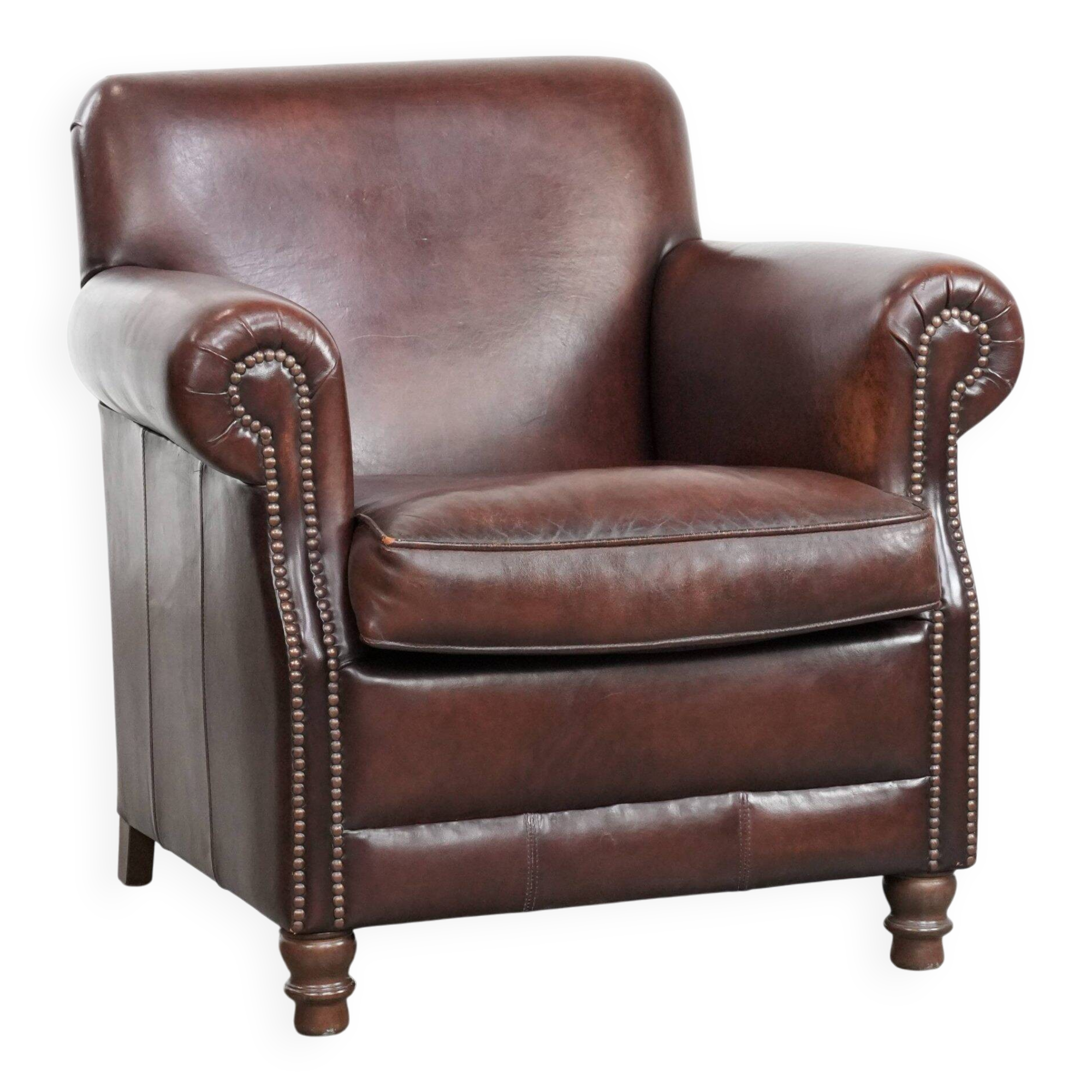 Sheepskin armchair with a classic finish and decorative studs.