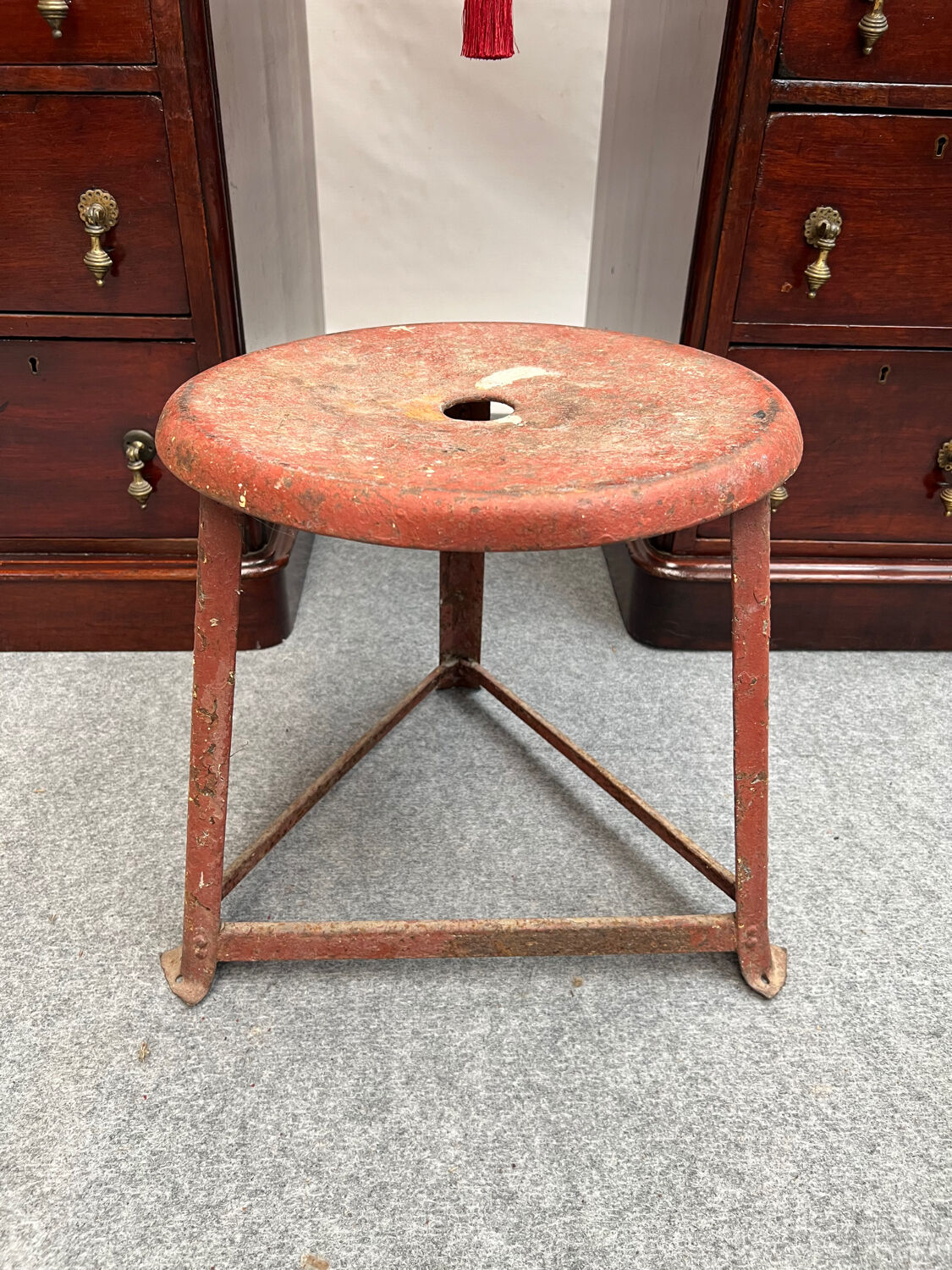 Red tripod industrial metal stool