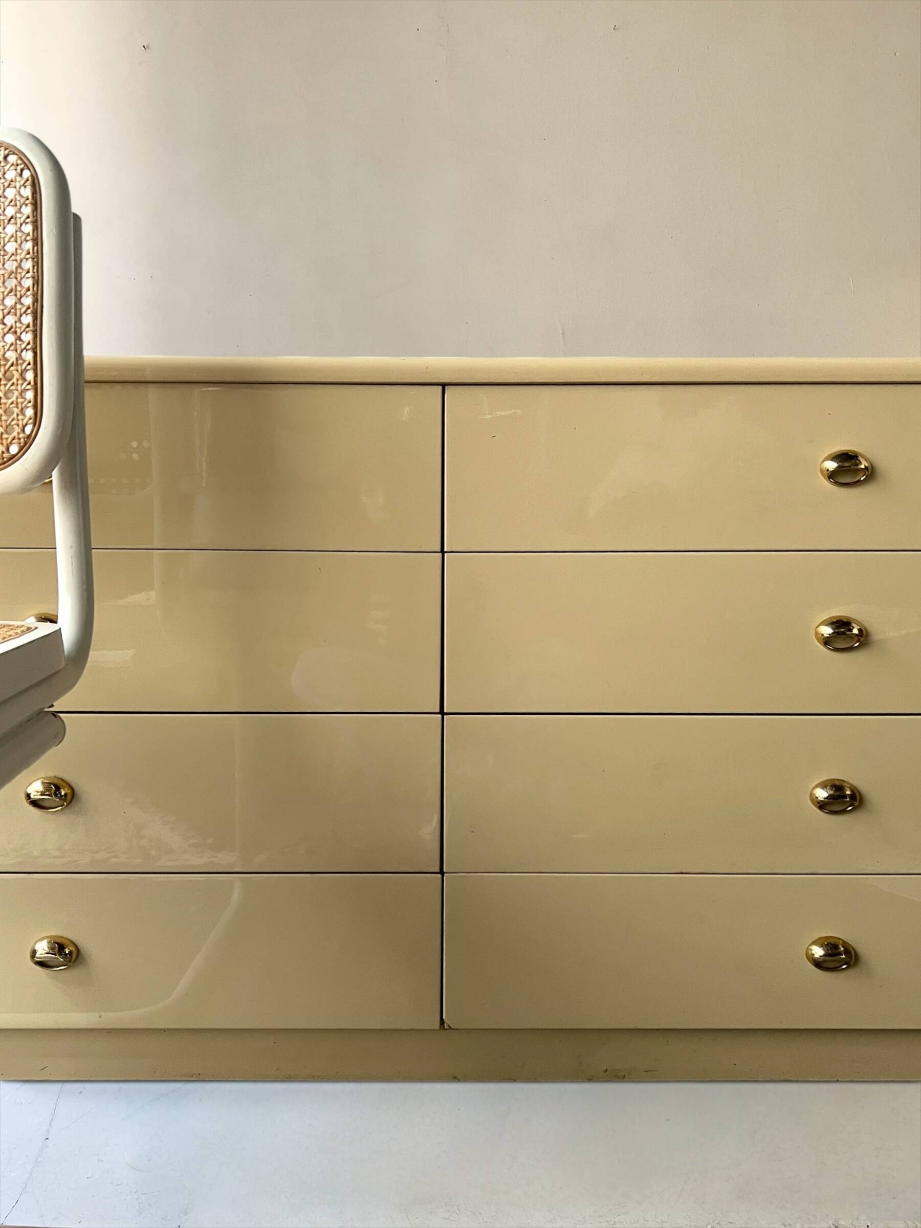 Commode type sideboard with 8 drawers, ivory lacquer and brass details, 1970s design.