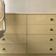 Commode type sideboard with 8 drawers, ivory lacquer and brass details, 1970s design.