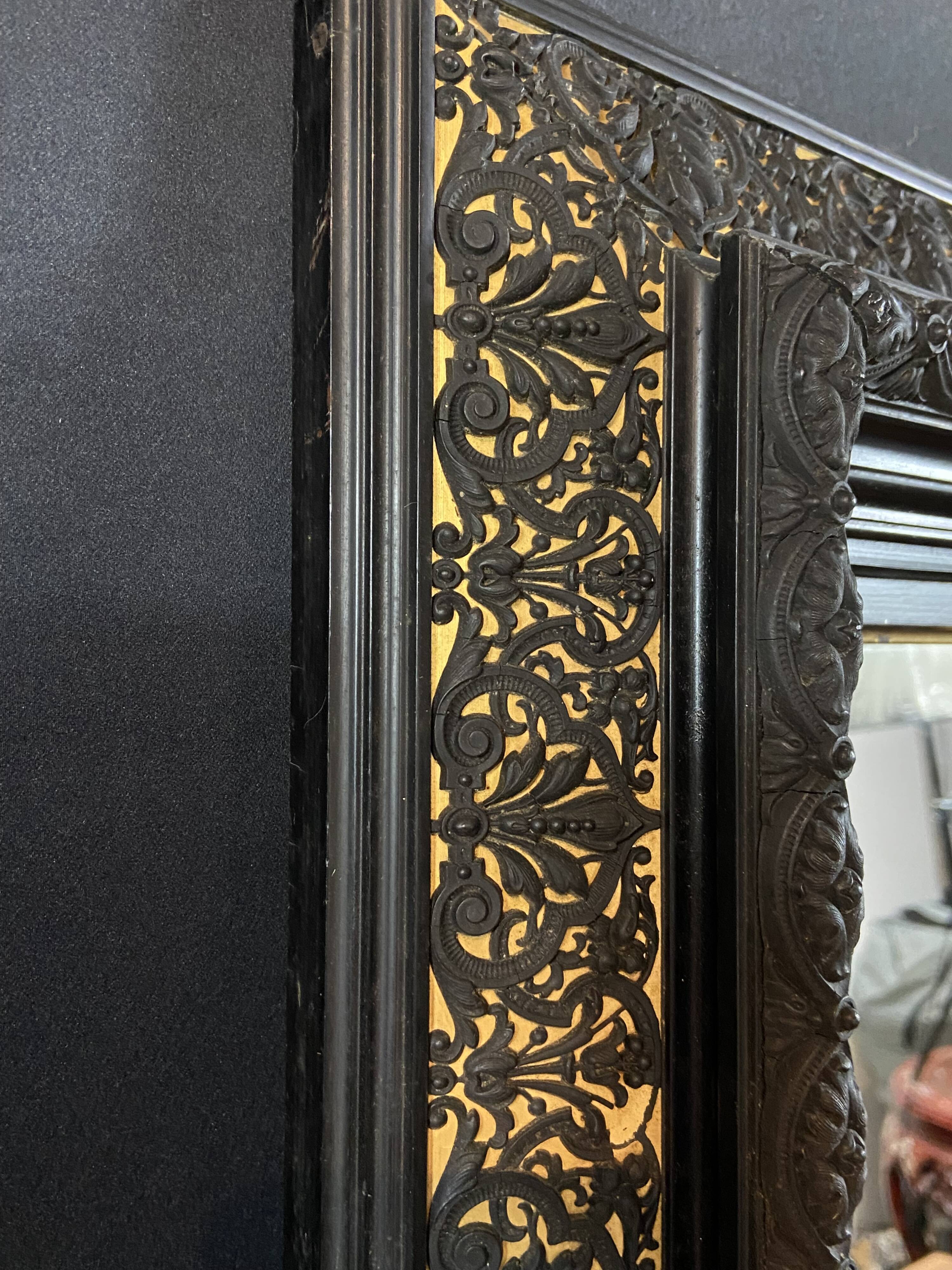 19th-century mirror Napoleon III in blackened wood on a gold background.