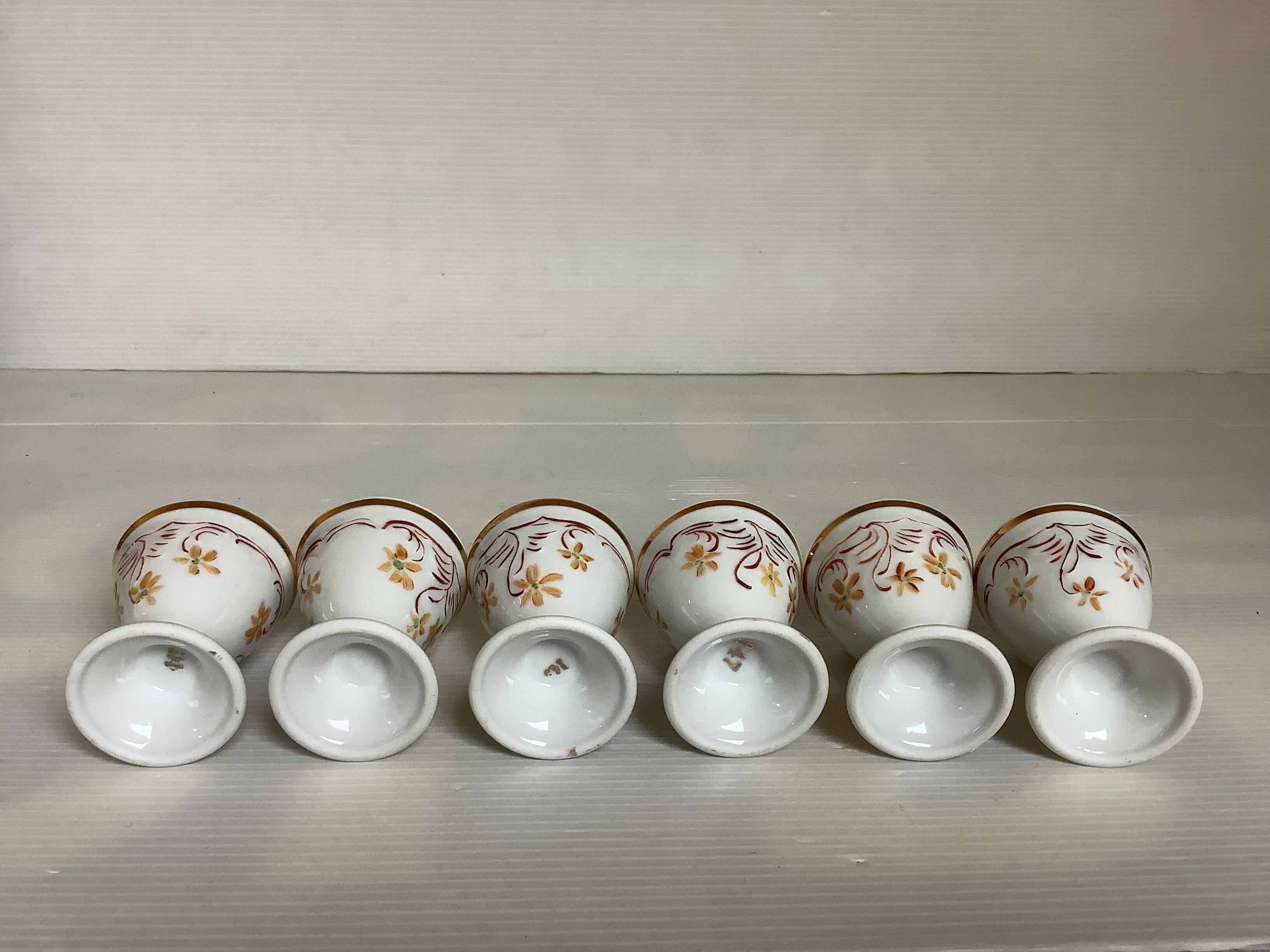 Six hand-decorated and signed egg cups