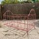 Old iron bed for children, painted pink with scrolls, romantic style.