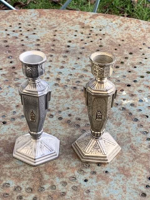 Pair of metal candlesticks, chiseled with a statuette in front, rose pattern in relief, art deco