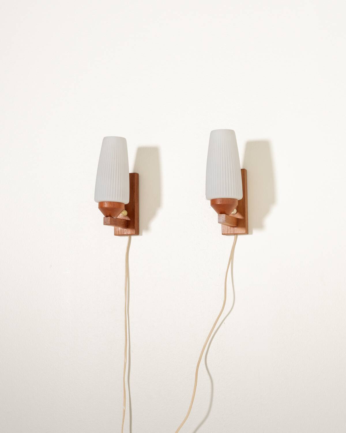 Pair of teak and opaline glass wall lamps, 1950s/1960s