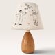 Wood-turned lamp with a hand-drawn lampshade, circus patterns.