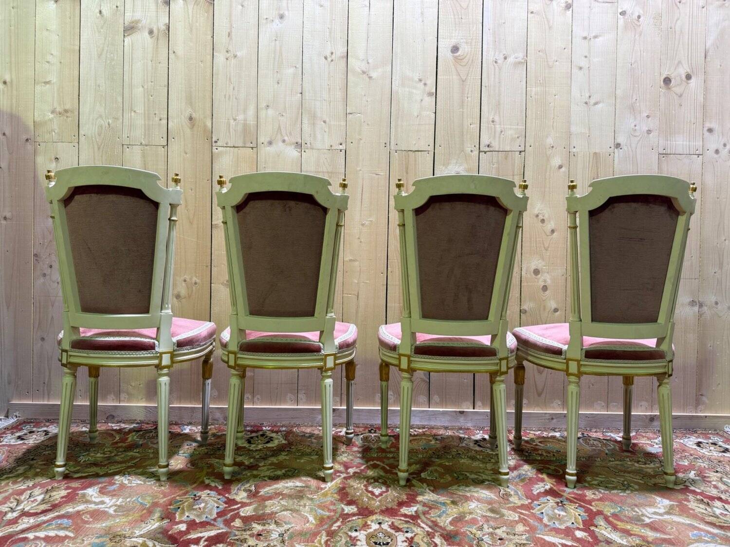 Louis XVI dining room table set with painted wood, gold accents, and pink velvet.
