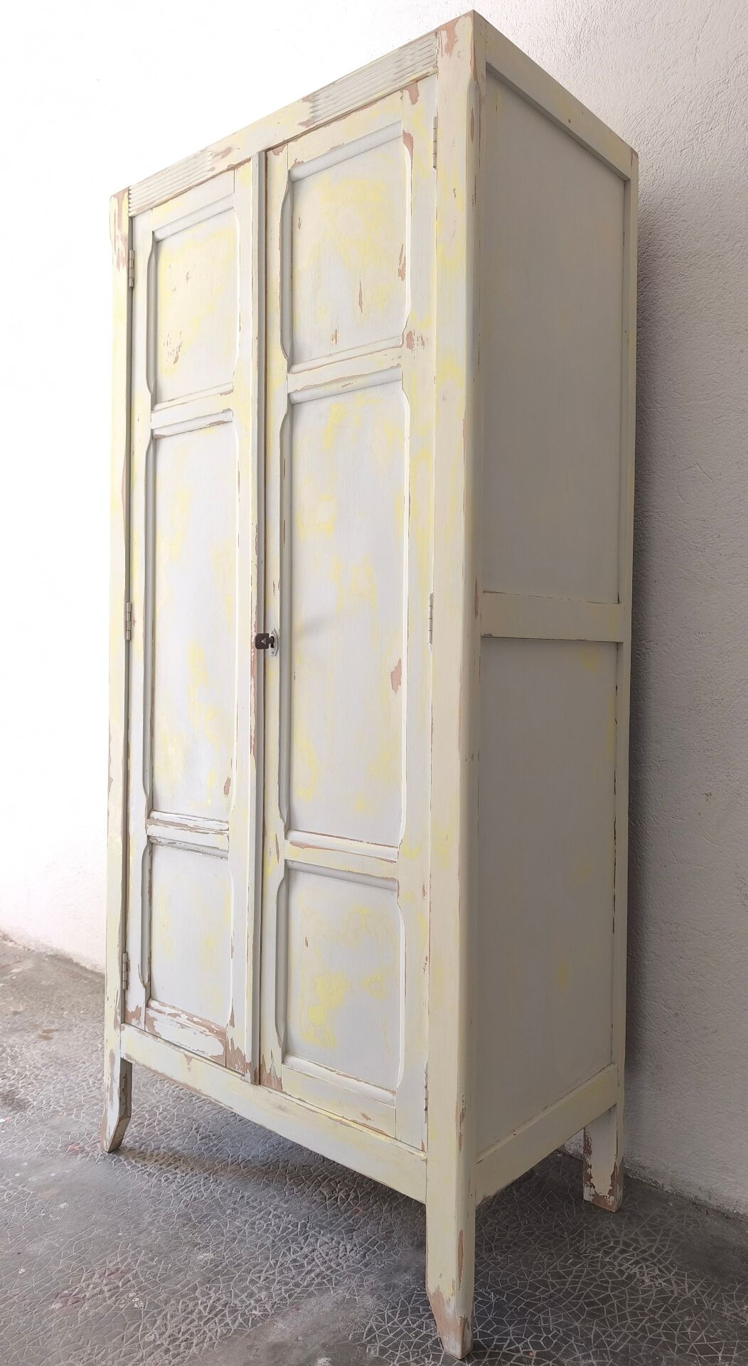 Small antique wardrobe patinated in beige and yellow.