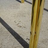 Nested tubular tables in gold metal.