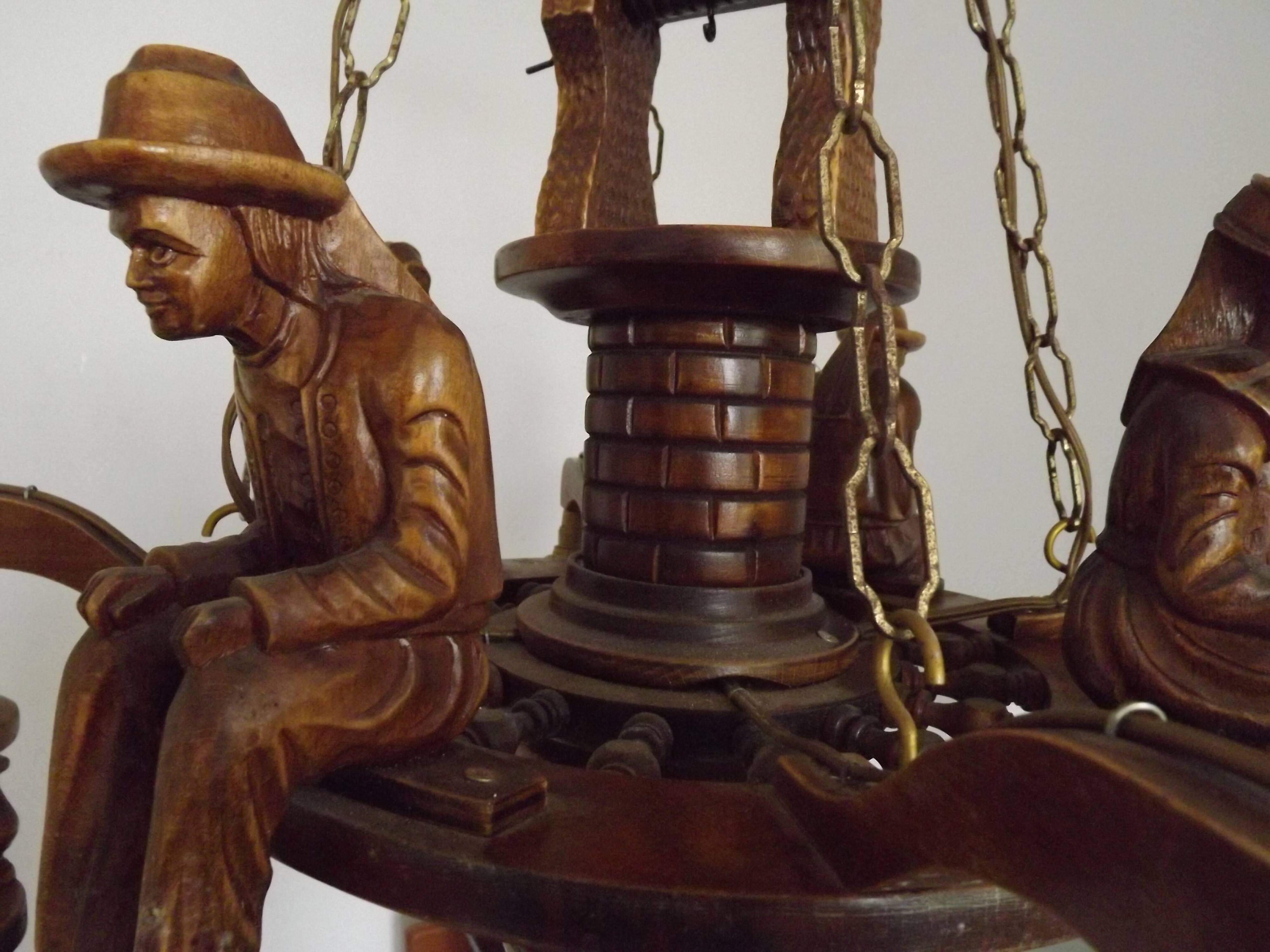 French vintage Breton chandelier with hand-carved figures, well, and lantern lights.