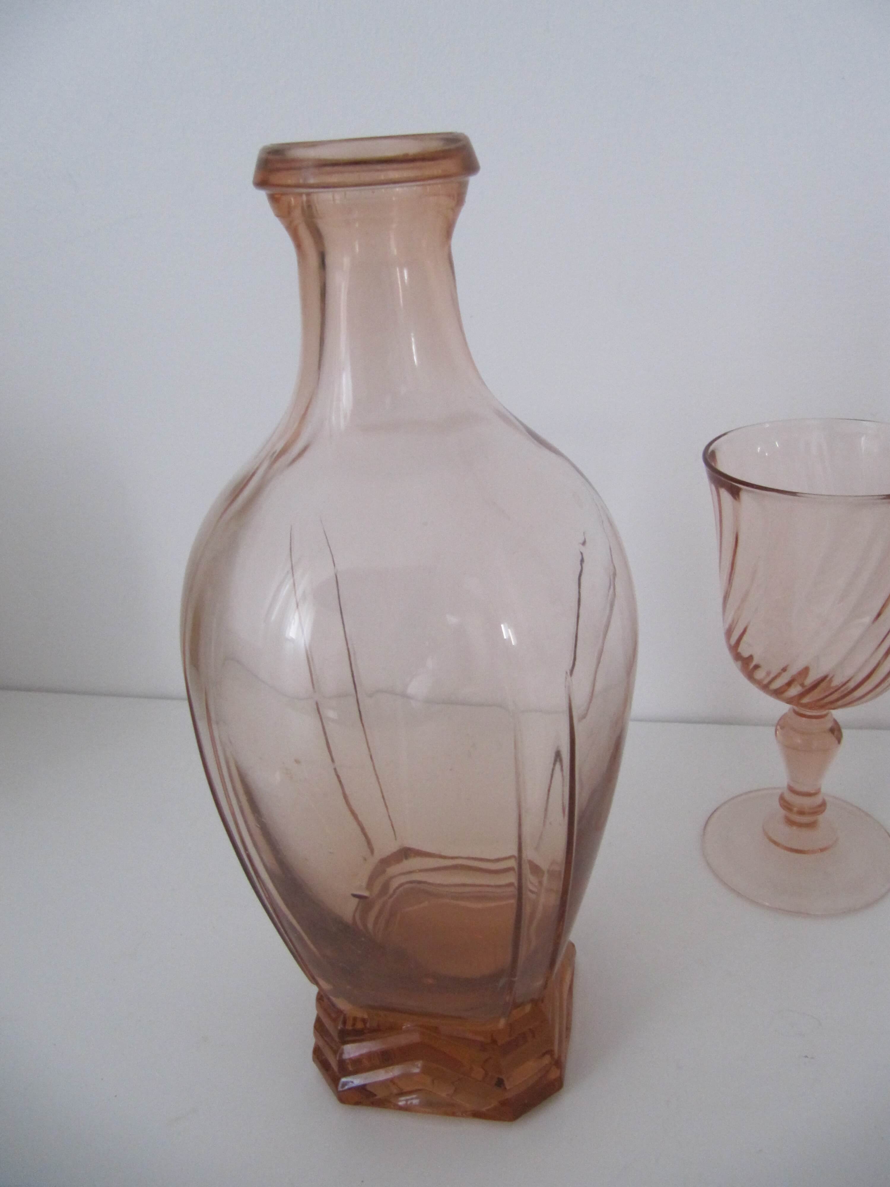 Old bottle in pink glass and 2 wine glasses