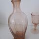 Old bottle in pink glass and 2 wine glasses