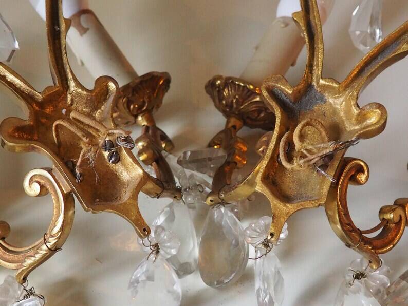 French antique Louis XV style twin arm wall sconces in bronze with crystals.