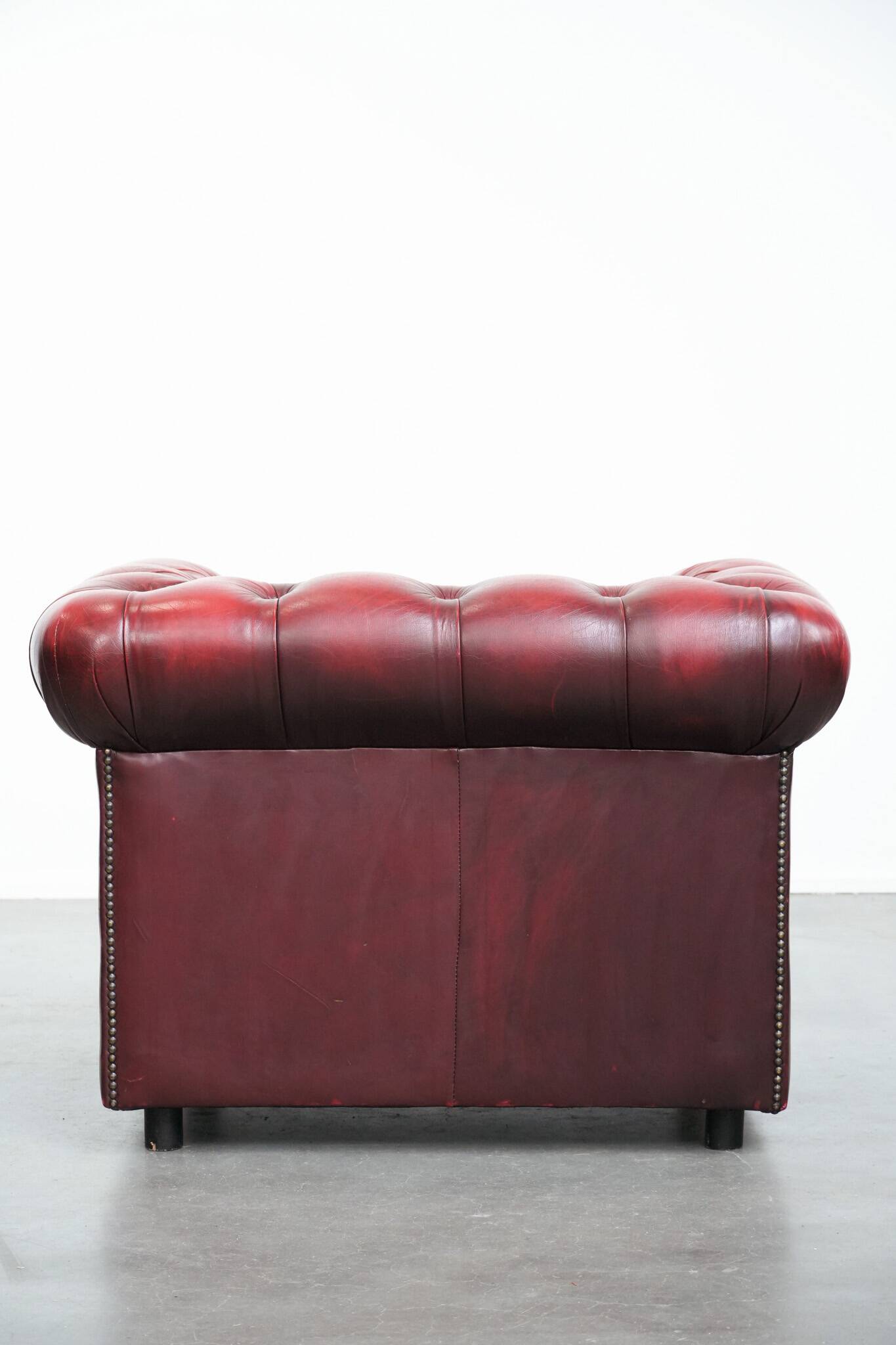 Red English cowhide Chesterfield armchair finished with decorative nails