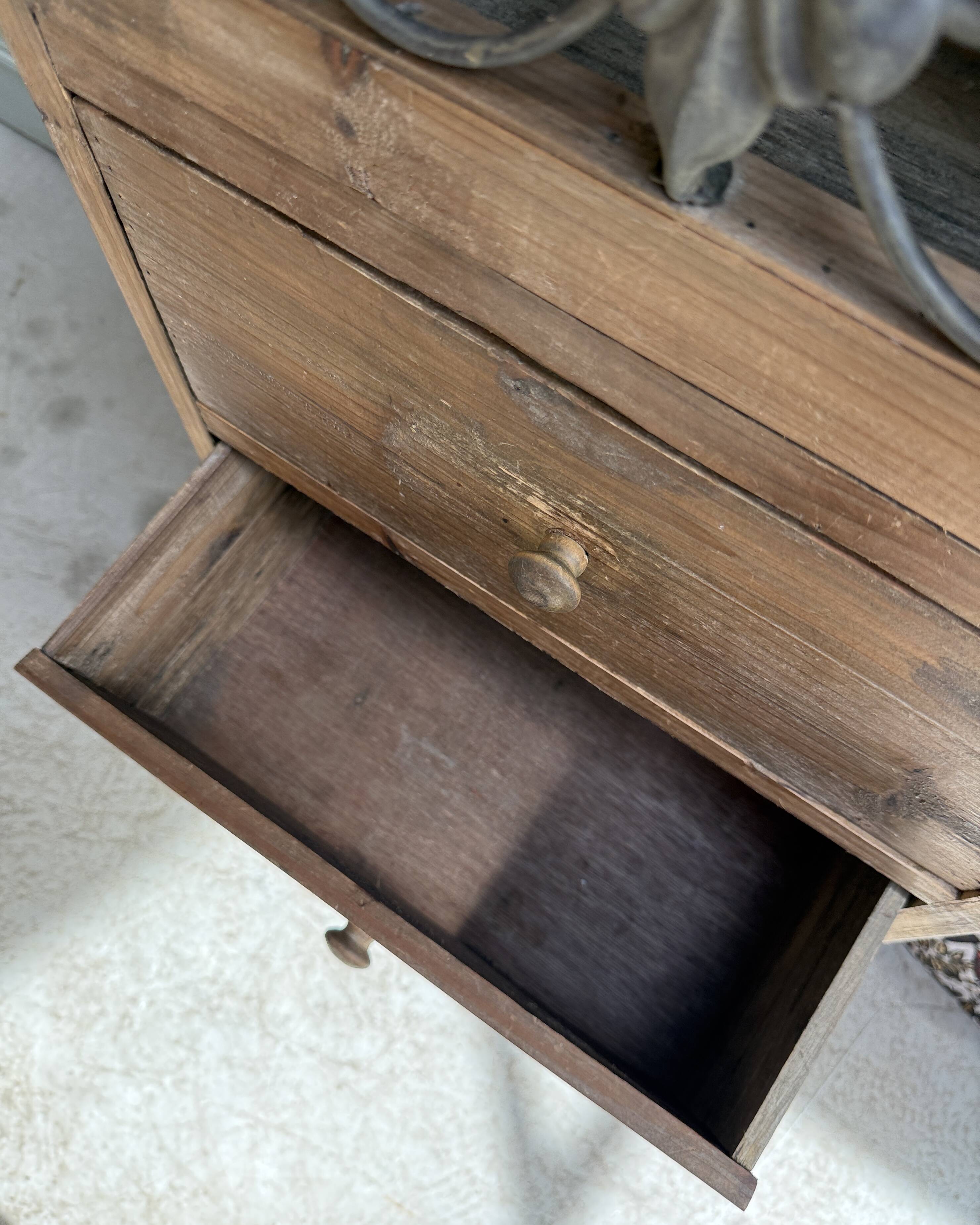 Column storage unit with a sculpted metal door.