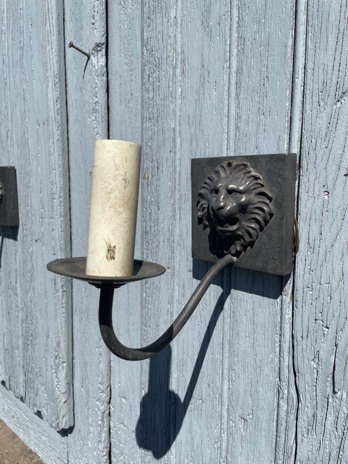 Two lion head wall sconces in tin.