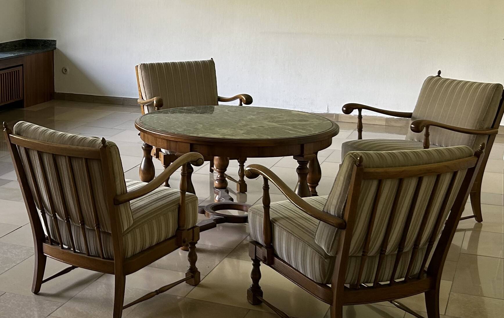 Ensemble de salon vintage avec table basse en marbre vert et quatre fauteuils.
