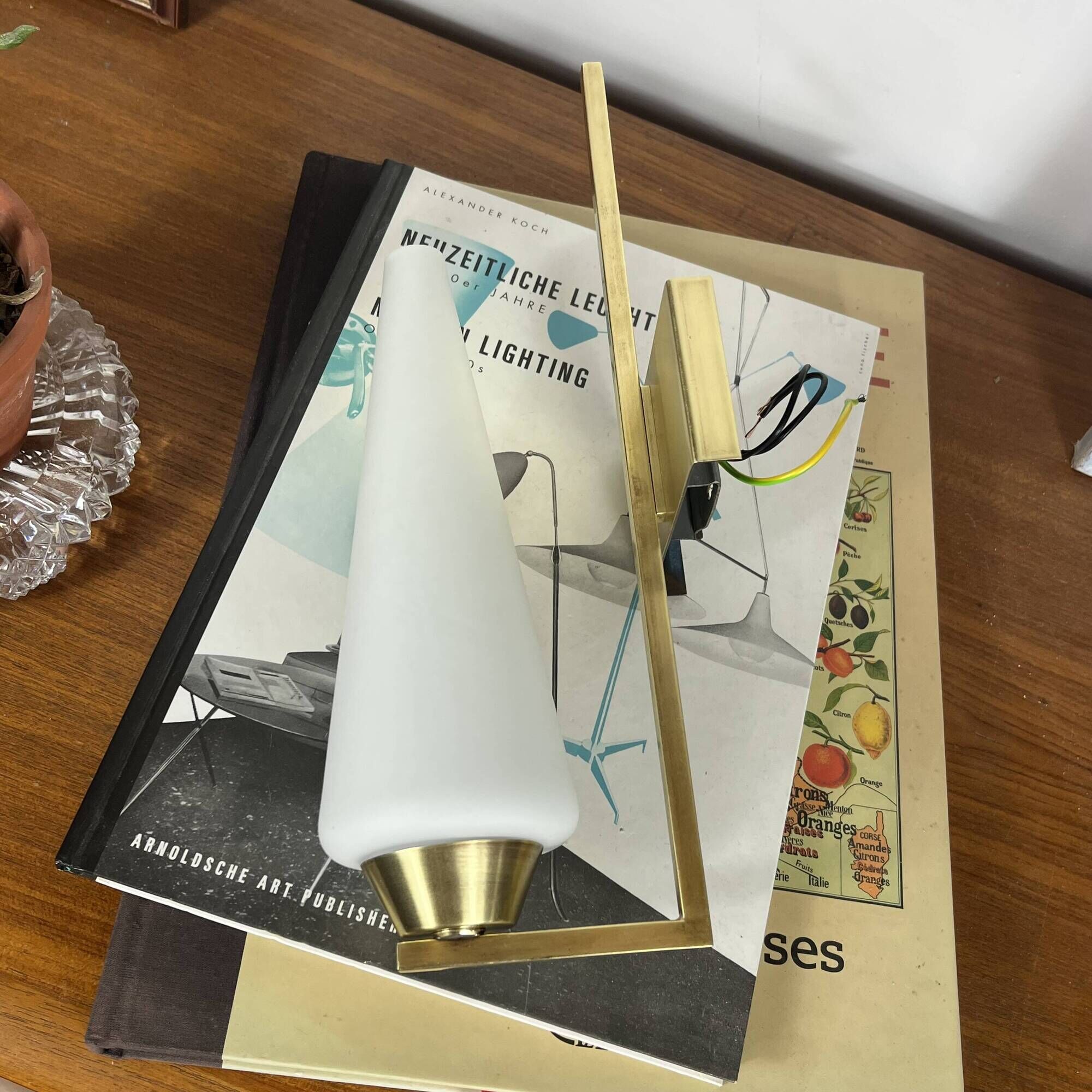 Vintage brass wall light with a white glass spindle shade from the 1950s-1960s.