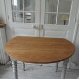 Walnut table with raised flaps, base on verdigris casters.