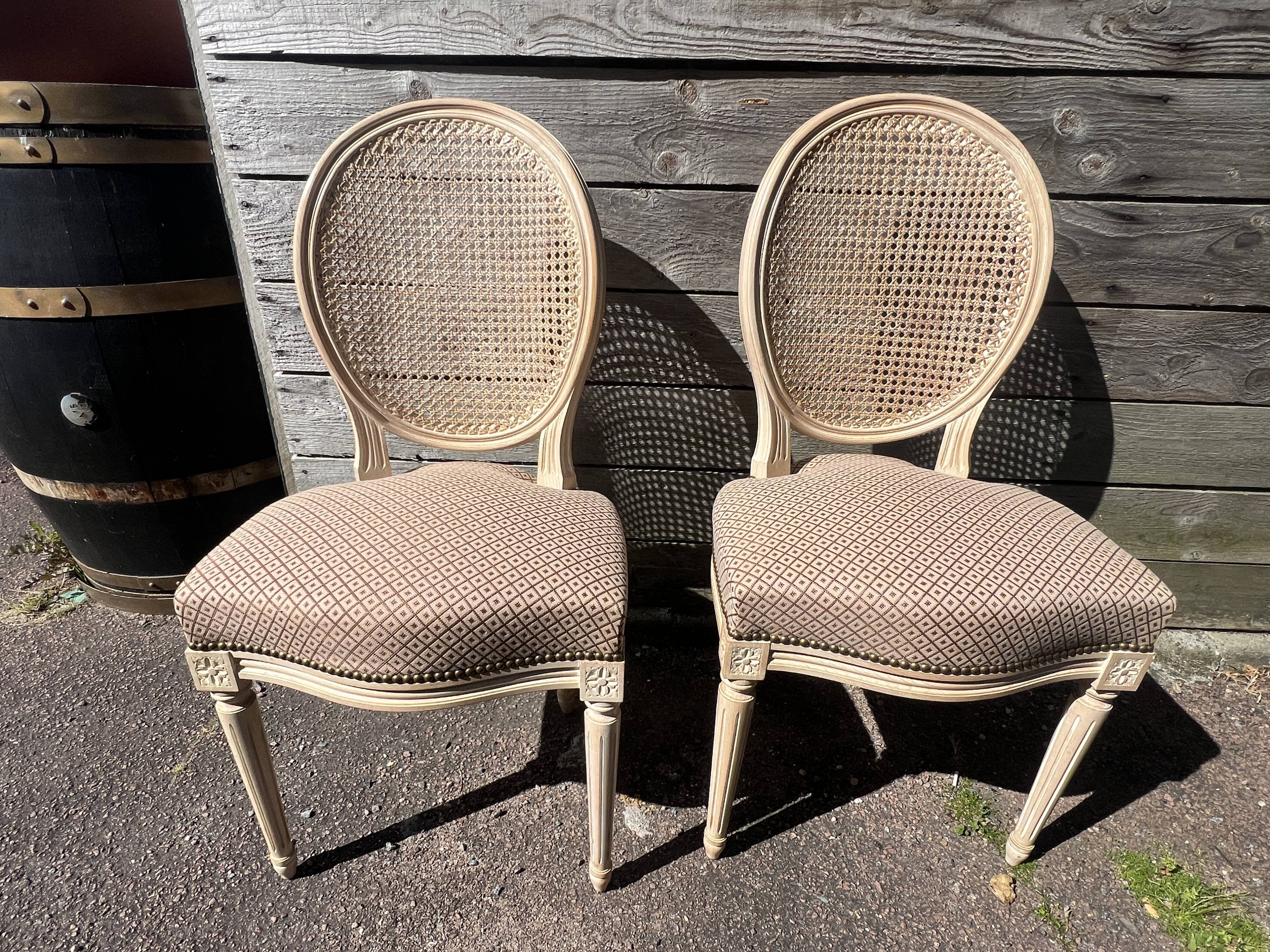 Pair of cerused chairs with fabric seats and caned backs.