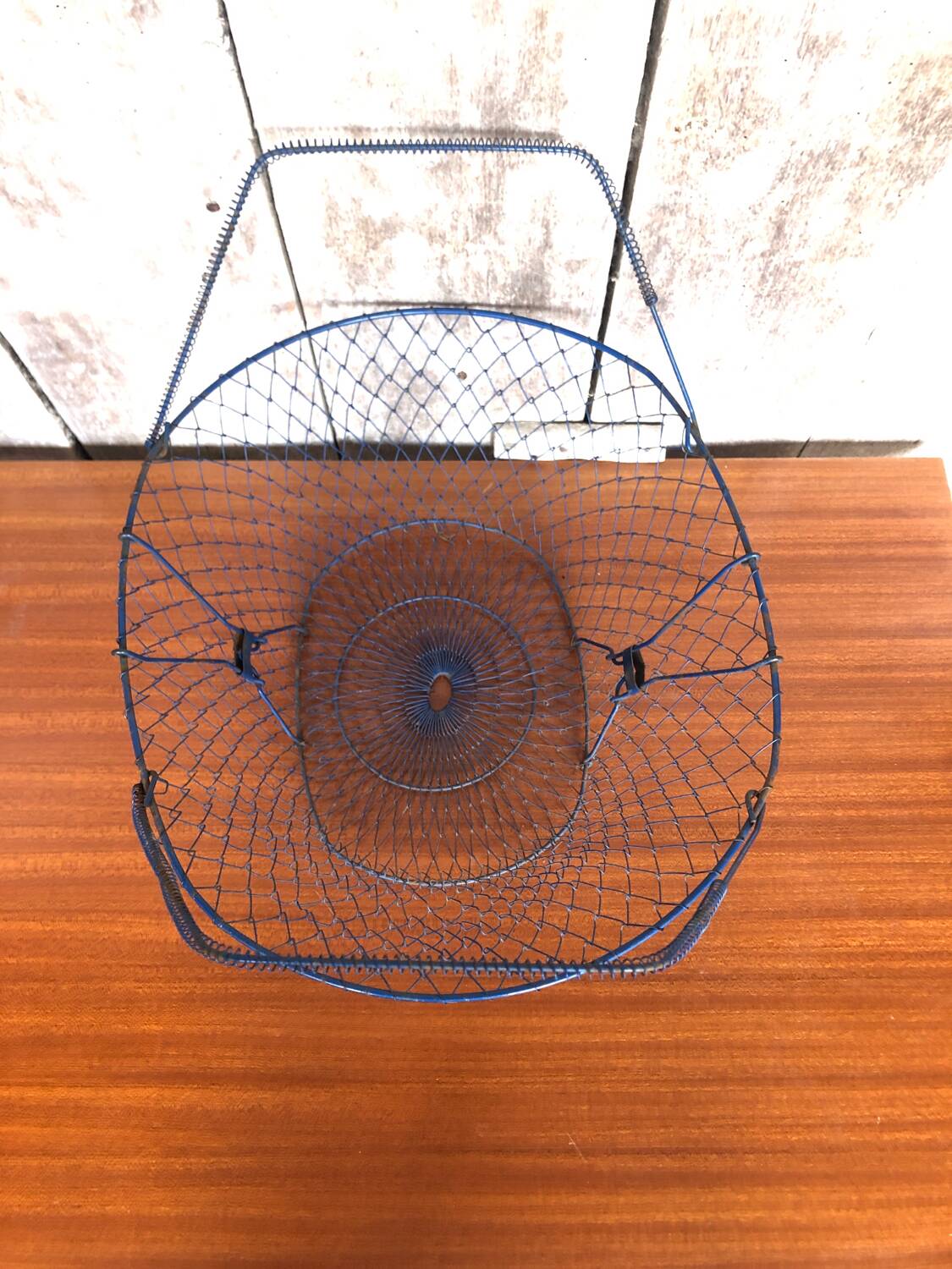 Old foldable blue metal basket, vintage handles