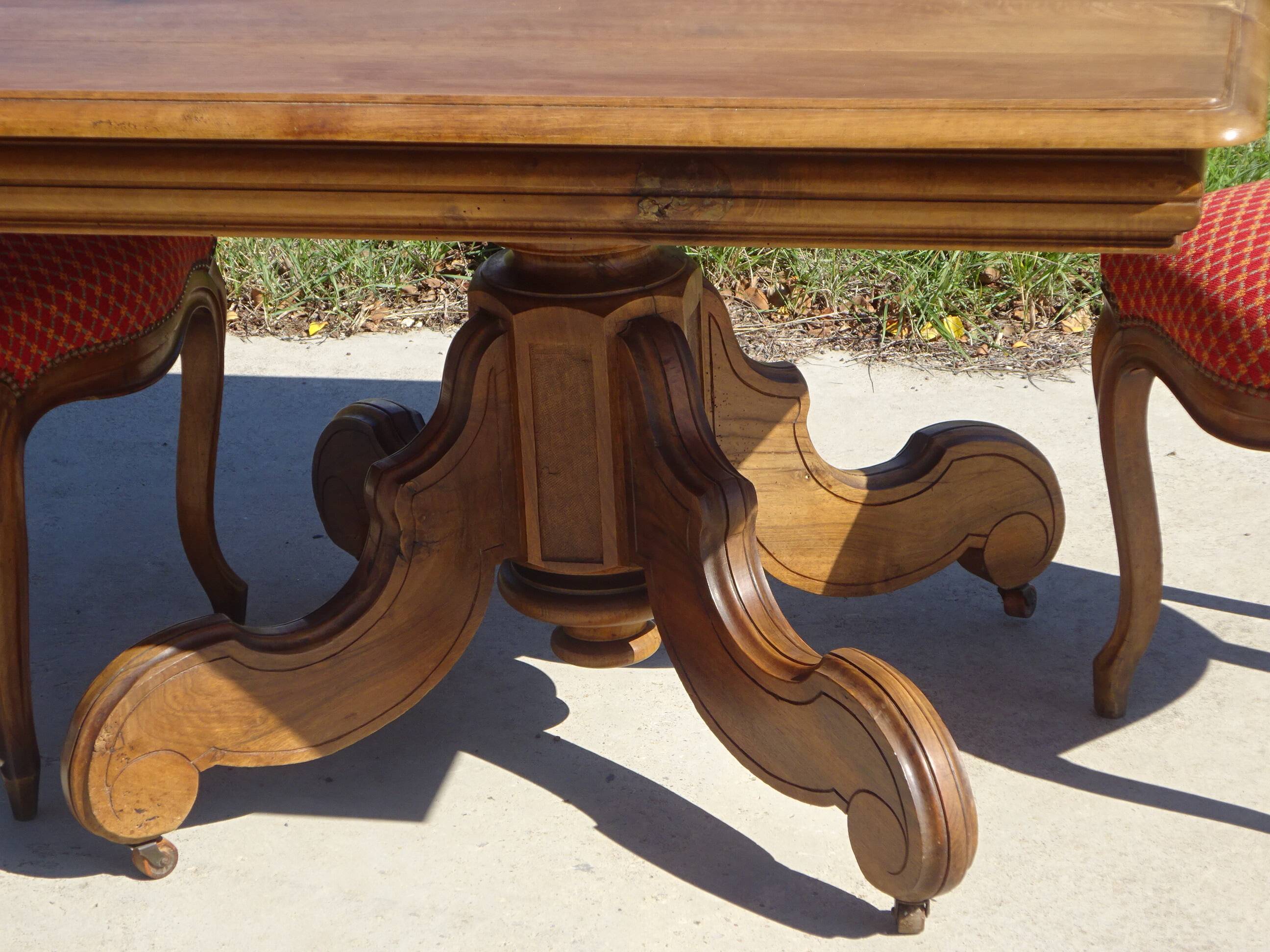 Old walnut table with a central leg.