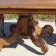 Old walnut table with a central leg.