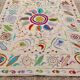 White suzani kilim rug with embroidered multi-colored patterns