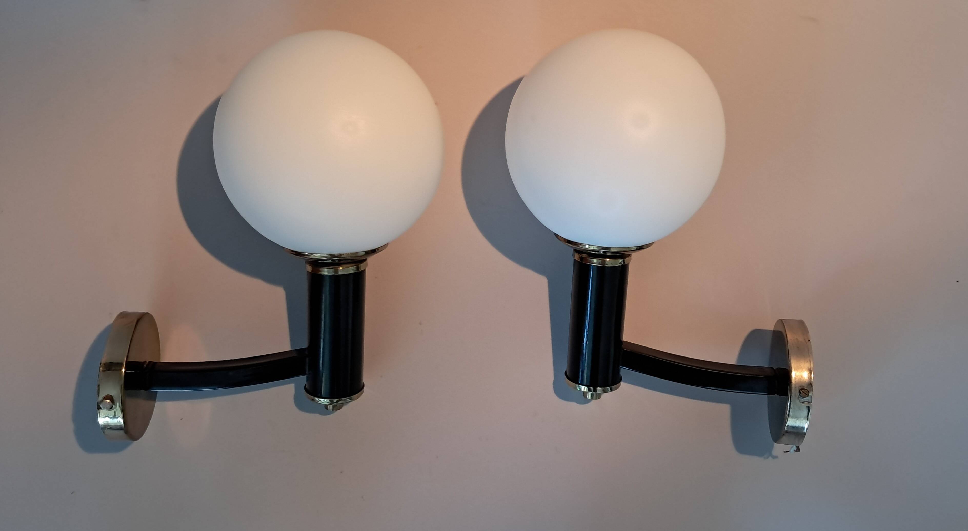 Pair of wall lights in gilded and black lacquered brass, Italy 1970/1980.