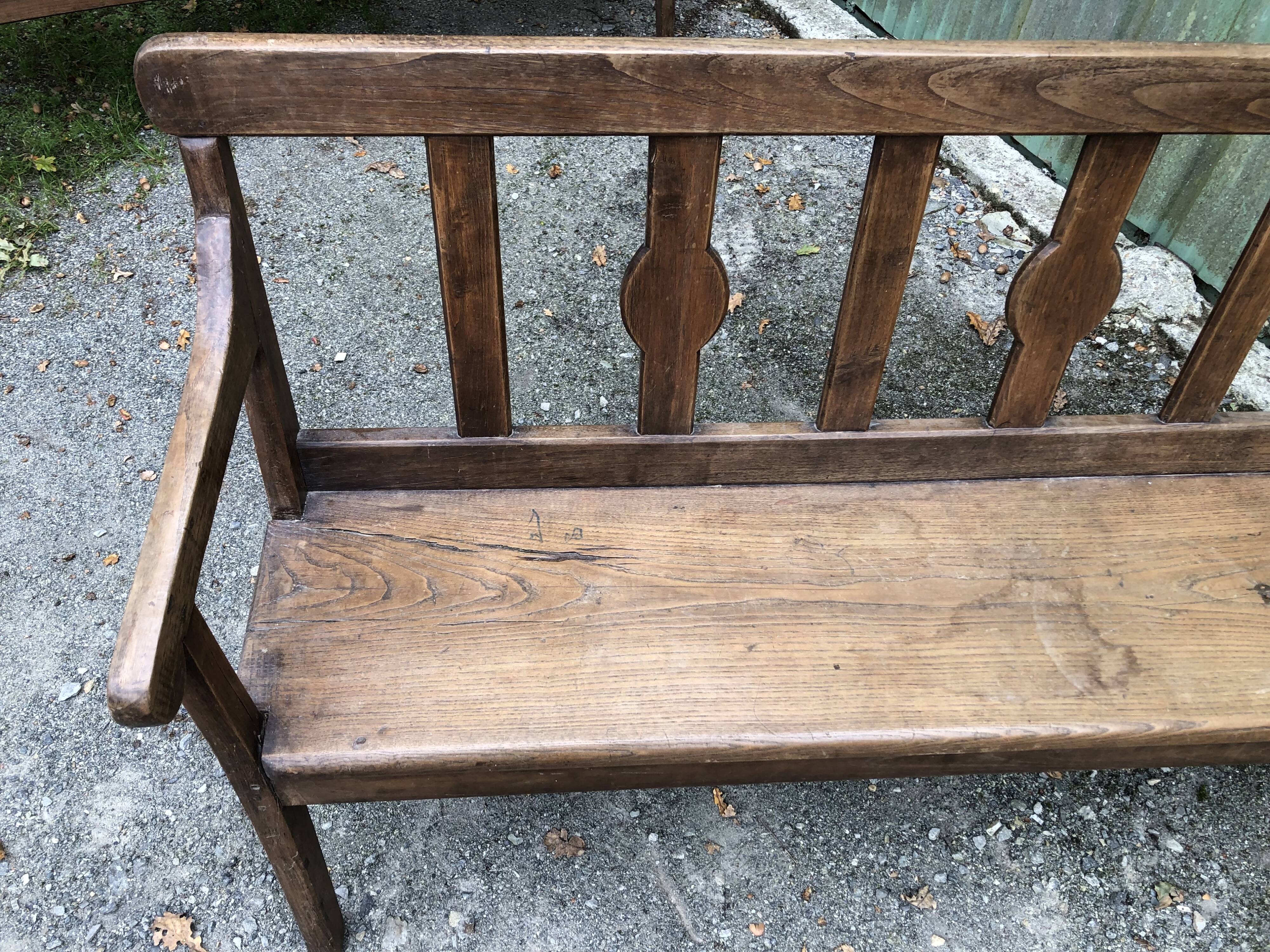 Duo of old solid oak benches with backs and armrests.