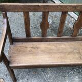 Duo of old solid oak benches with backs and armrests.