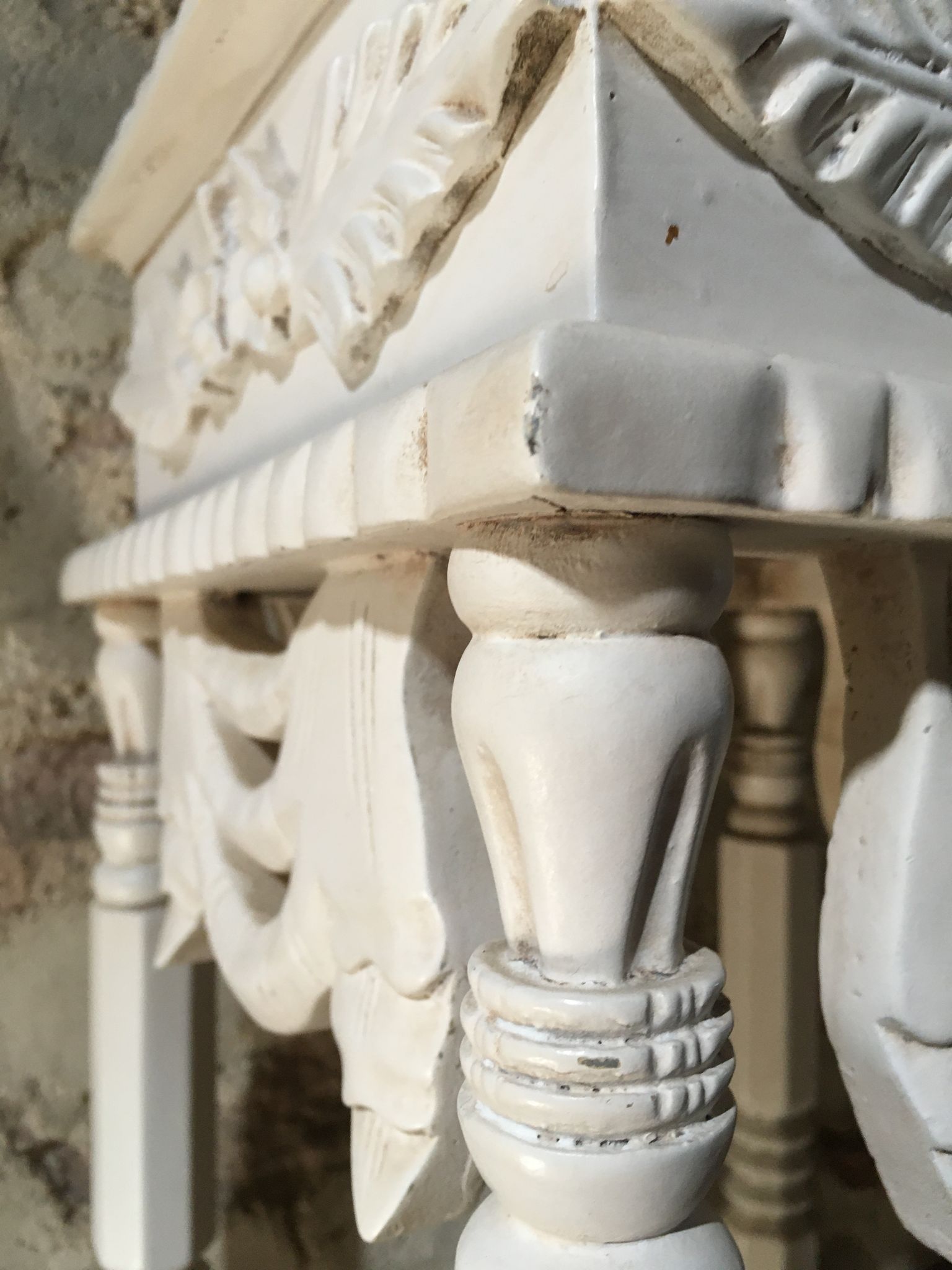 Carved wooden stool with a white patina.