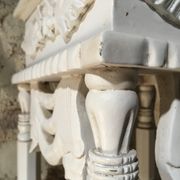 Carved wooden stool with a white patina.
