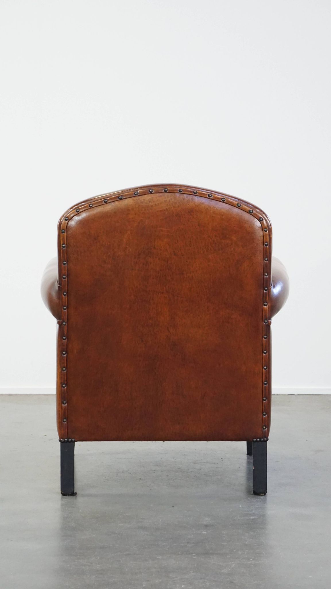 Sheep leather design armchair finished with decorative nails and black piping