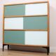 A vintage mid-century 3 tiered bookcase with glass sliding doors
