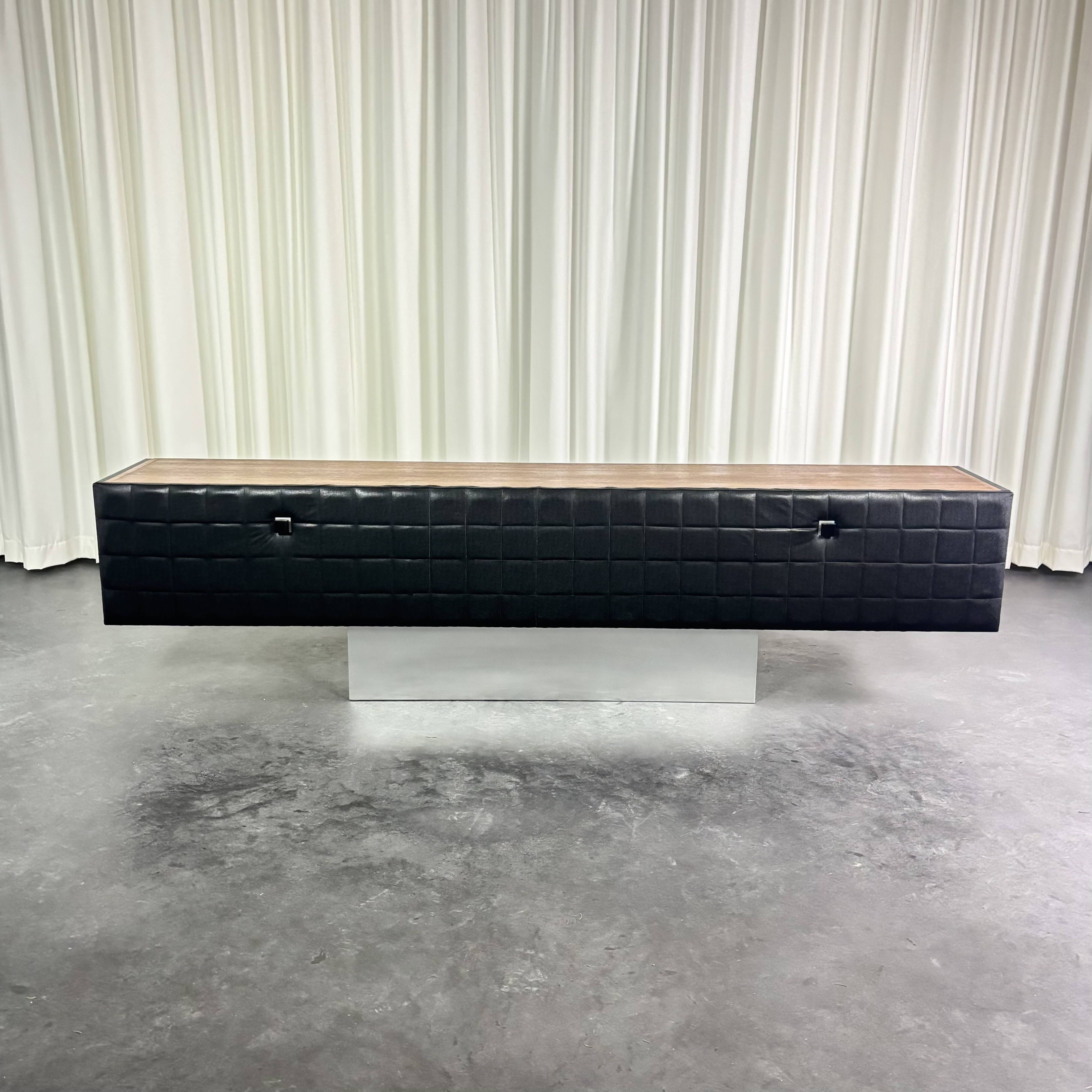 Modernist lowboard, faux leather, wood and stainless steel, 1960.