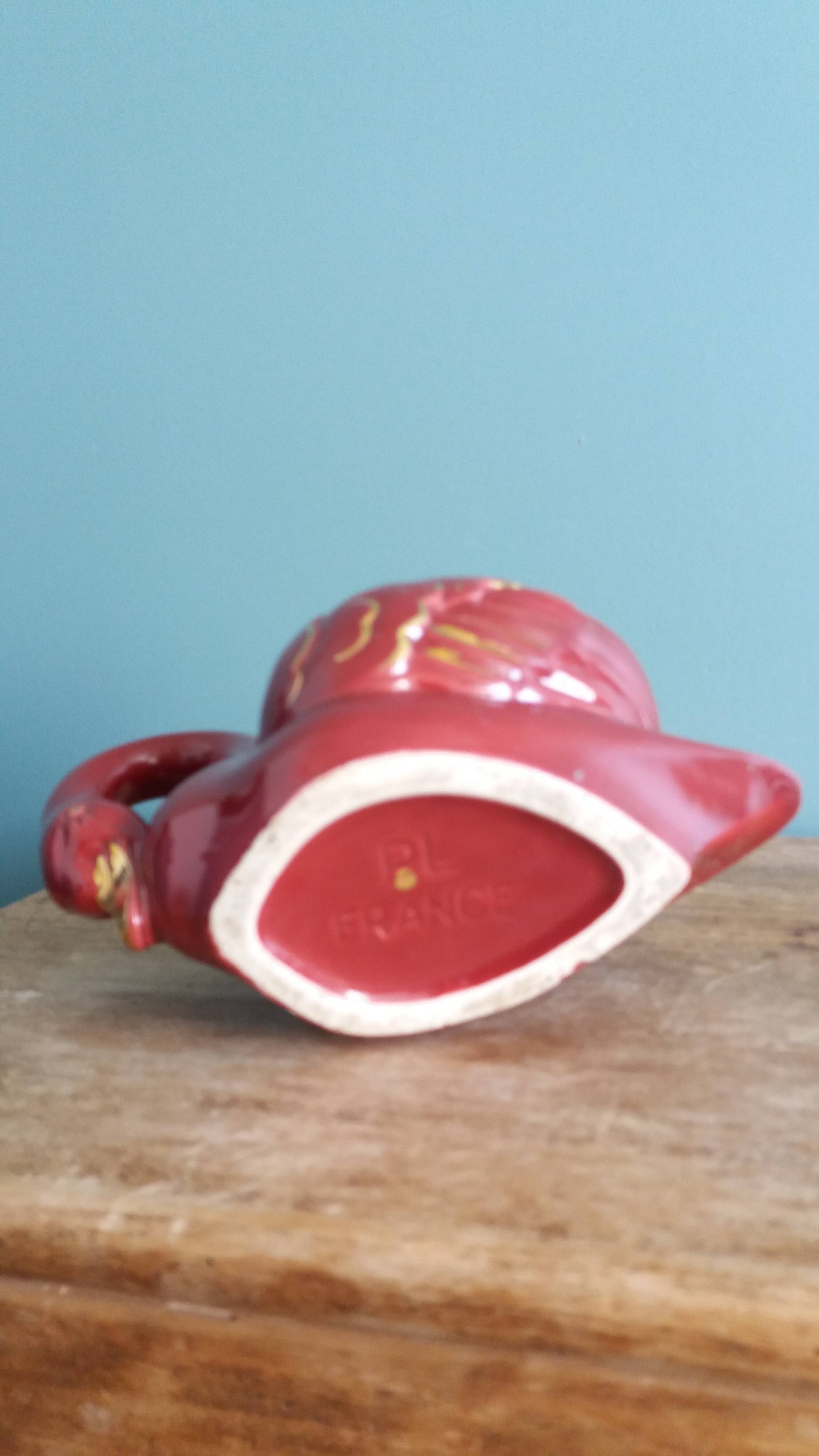 Poet Laval swan hides zoomorphic pot in burgundy ceramic.