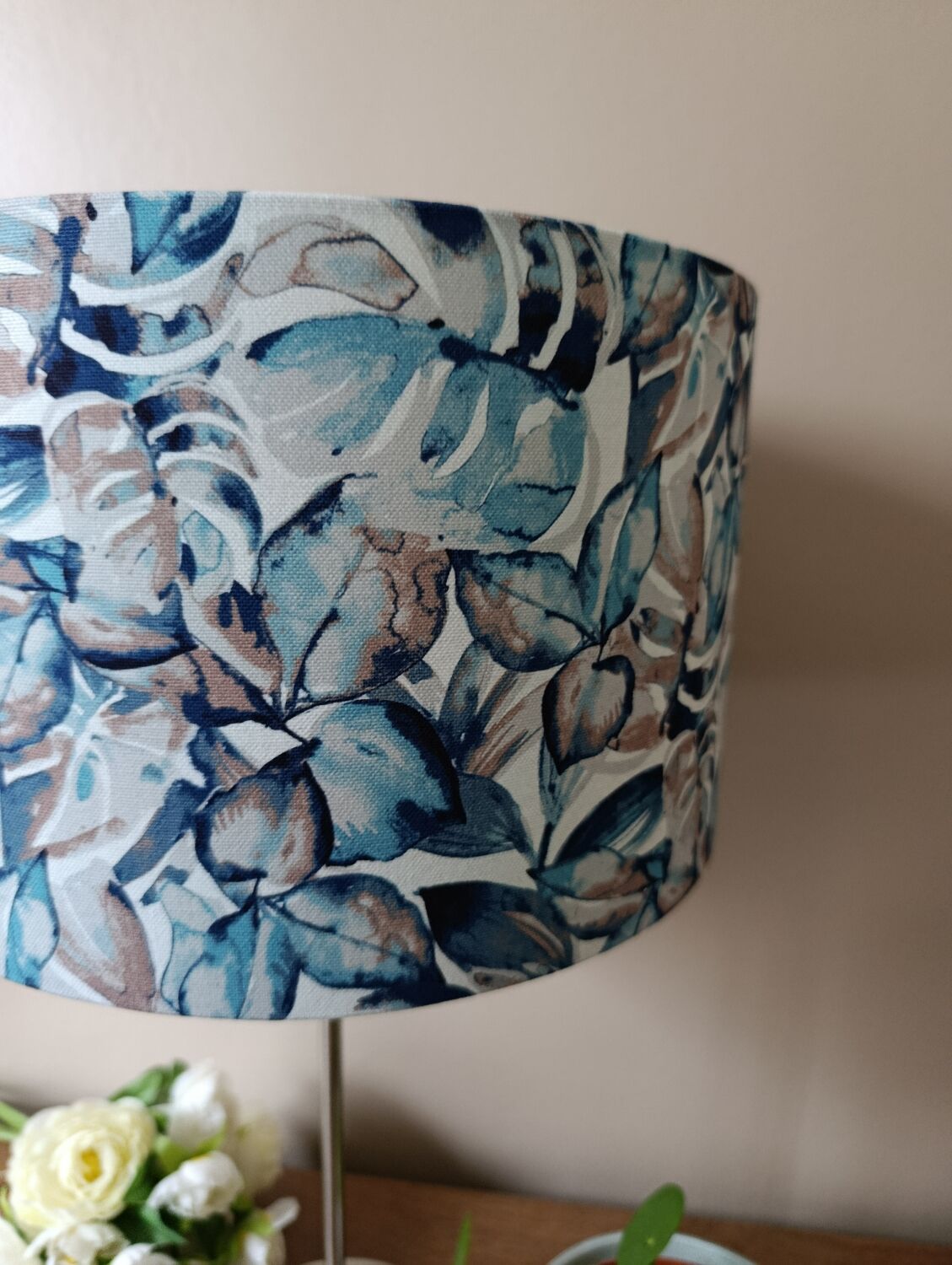 Table lamp with chrome stem, tropical plant shade.