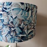 Table lamp with chrome stem, tropical plant shade.