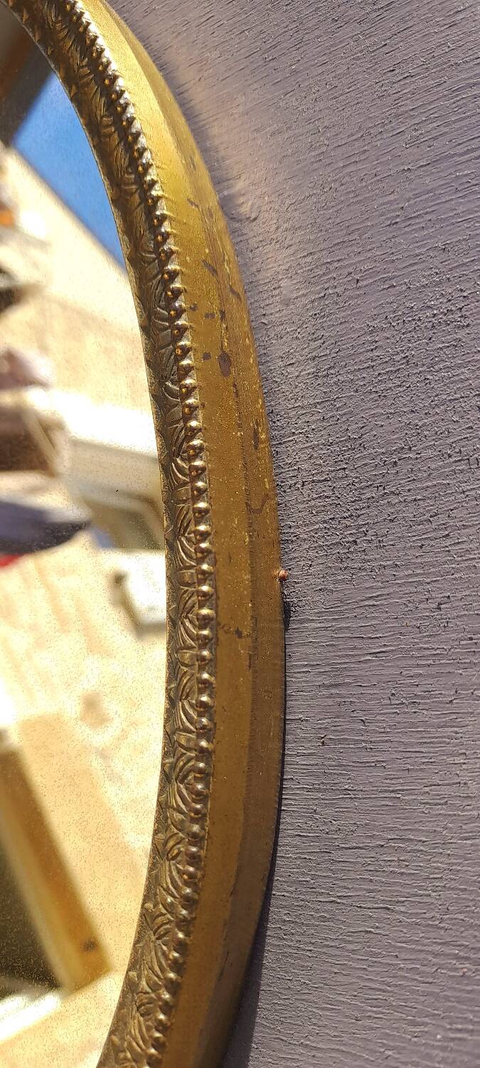 Oval mirror in gold metal