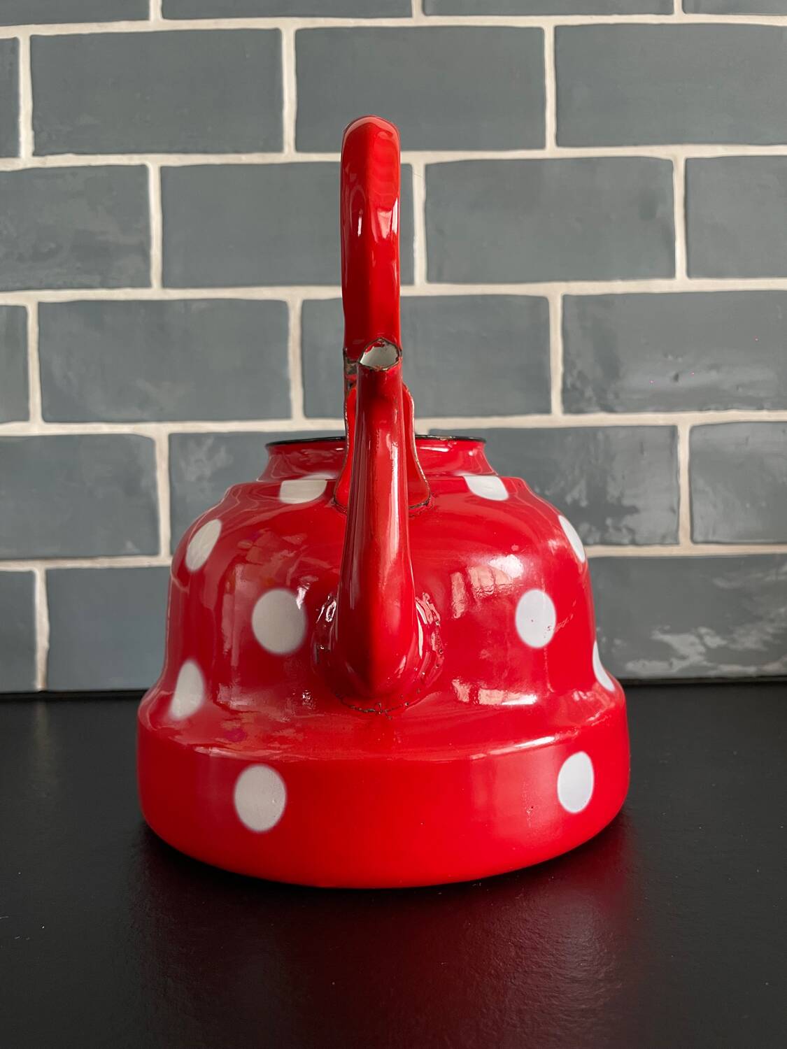 Red enameled sheet metal kettle with white polka dots
