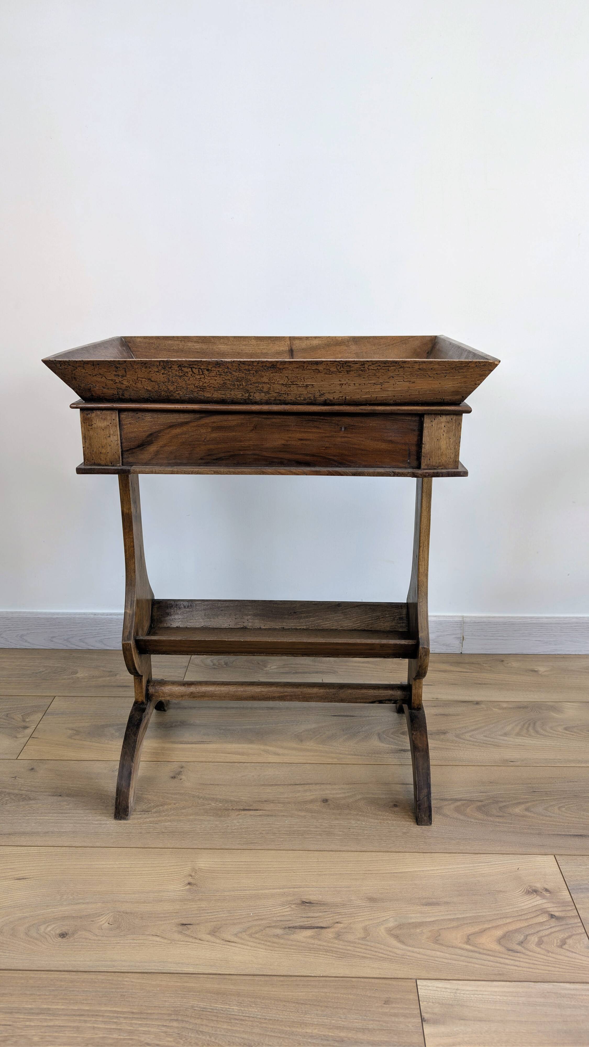 Old wooden pocket emptying table with drawer and planter.