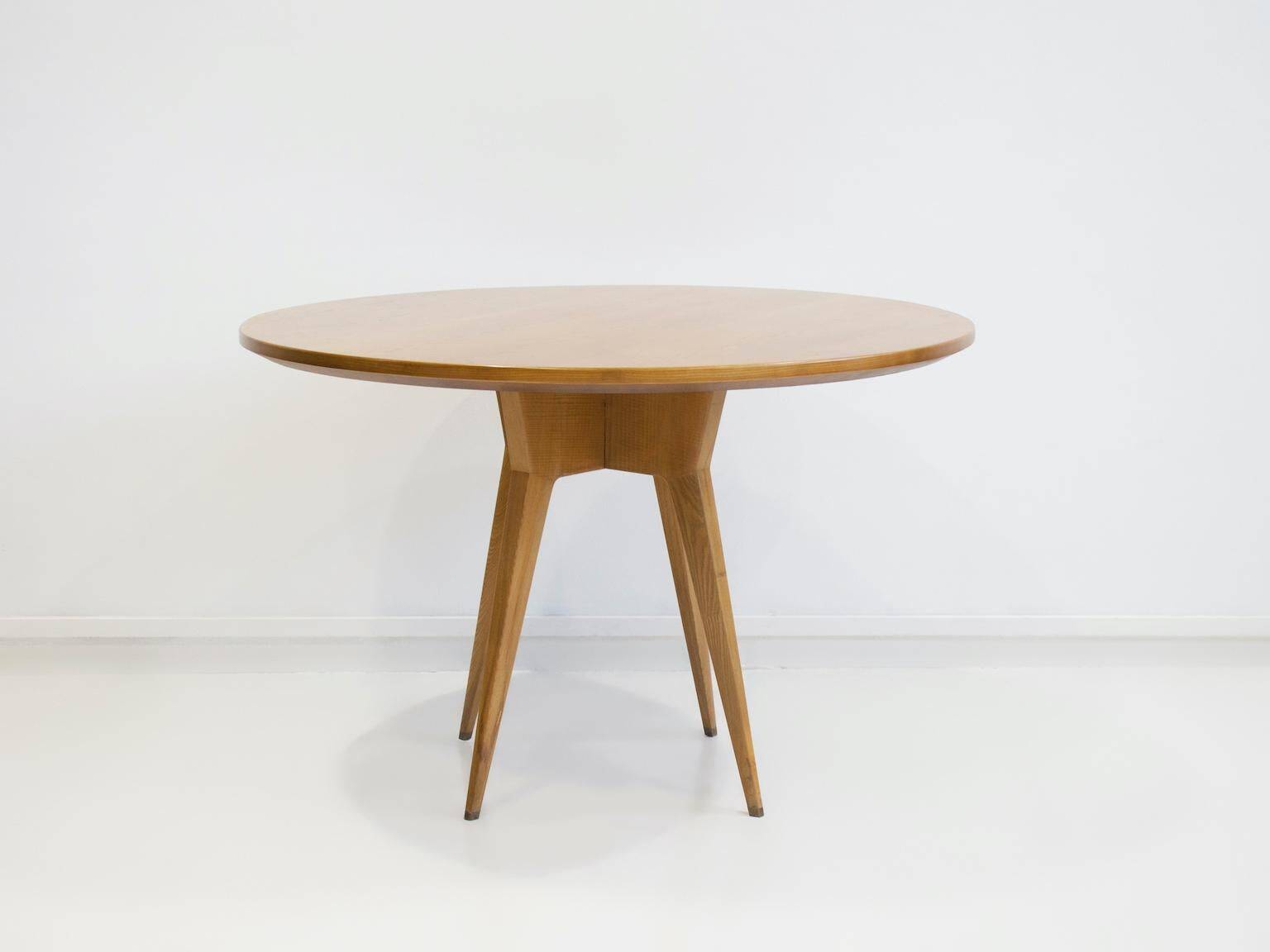 Round dining table in Wood Wood with brass details.