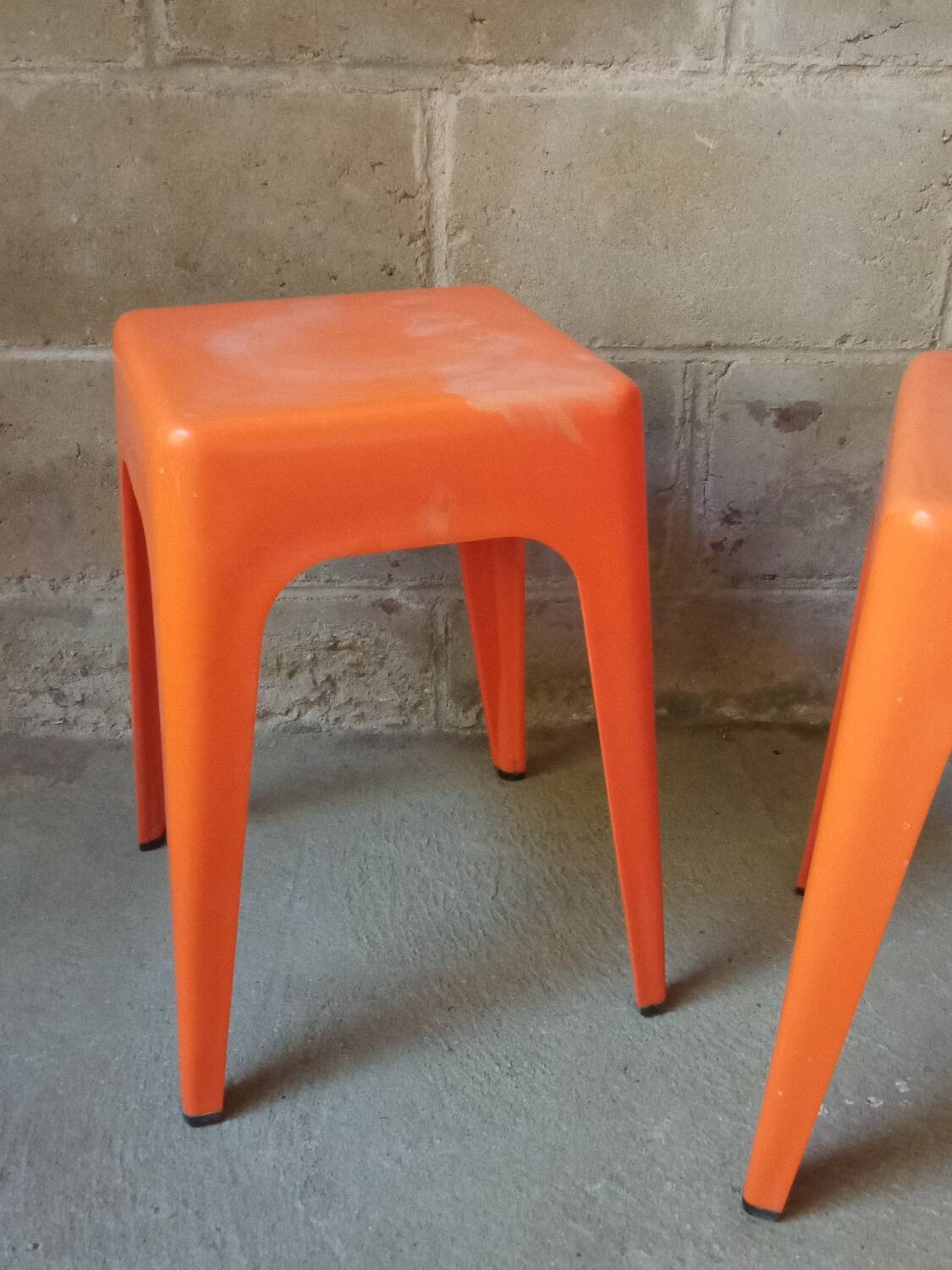 Pair of AMI stools in orange plastic